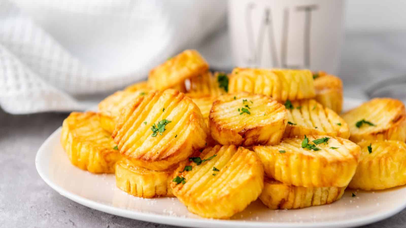 Crispy potato wedges served on a plate with a cup of coffee.