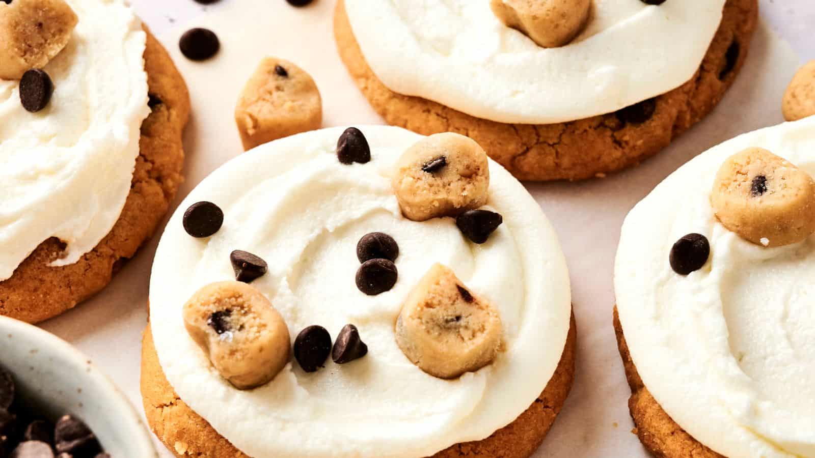 Enjoy these delectable cookies topped with white frosting, chocolate chips, and small cookie dough pieces—a perfect Copycat Crumbl Cookie Dough Cookie recipe.