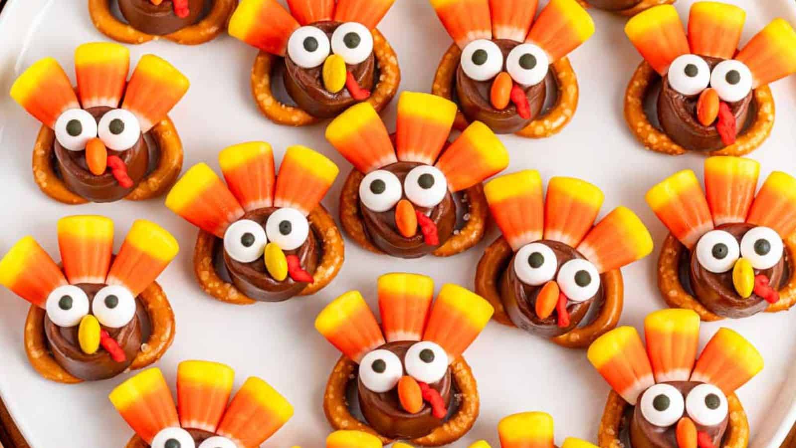 A festive plate of Rolo Pretzel Thanksgiving Turkeys crafted with chocolate, pretzels, candy corn, and candy eyes.