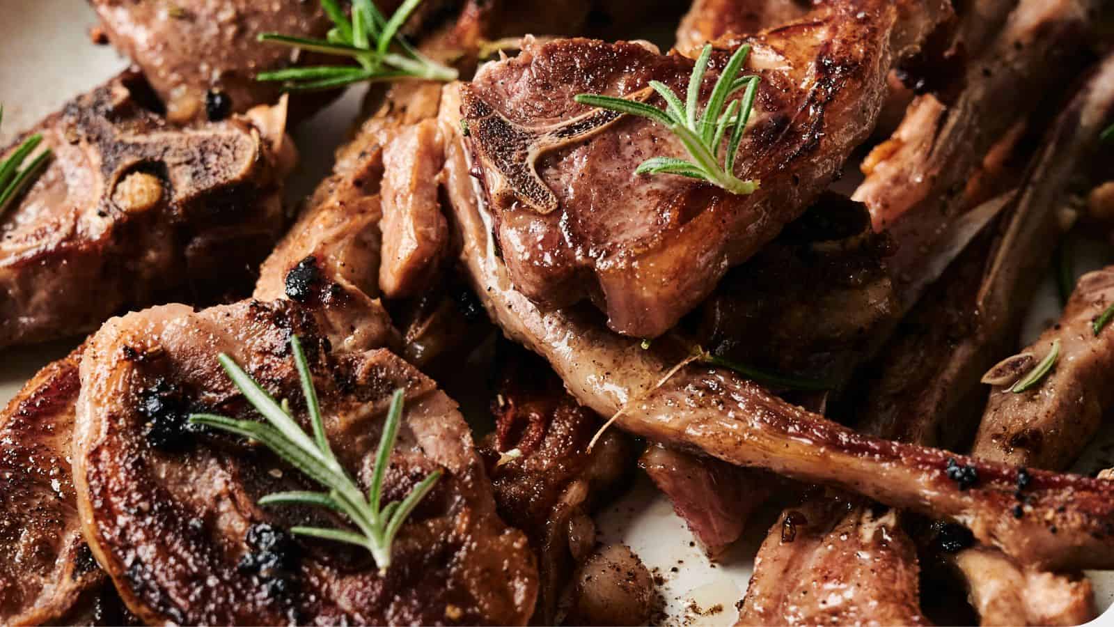 Grilled lamb chops garnished with fresh rosemary sprigs.