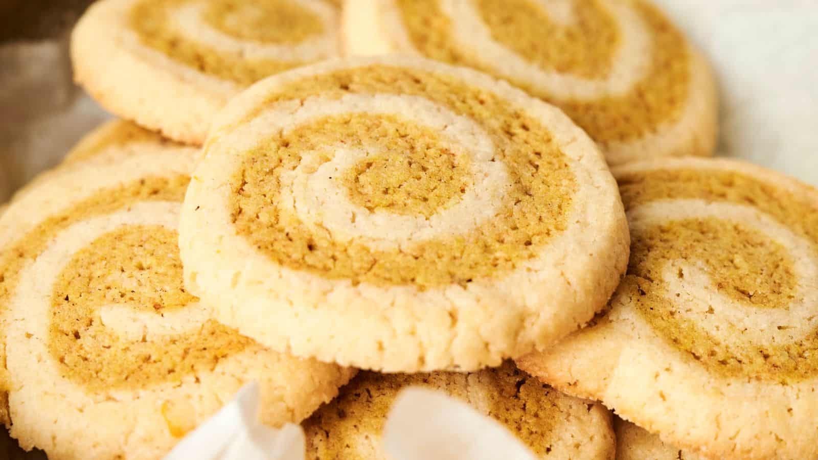Close-up of a stack of swirled cookies with a light and dark pattern, showcasing a golden brown color.