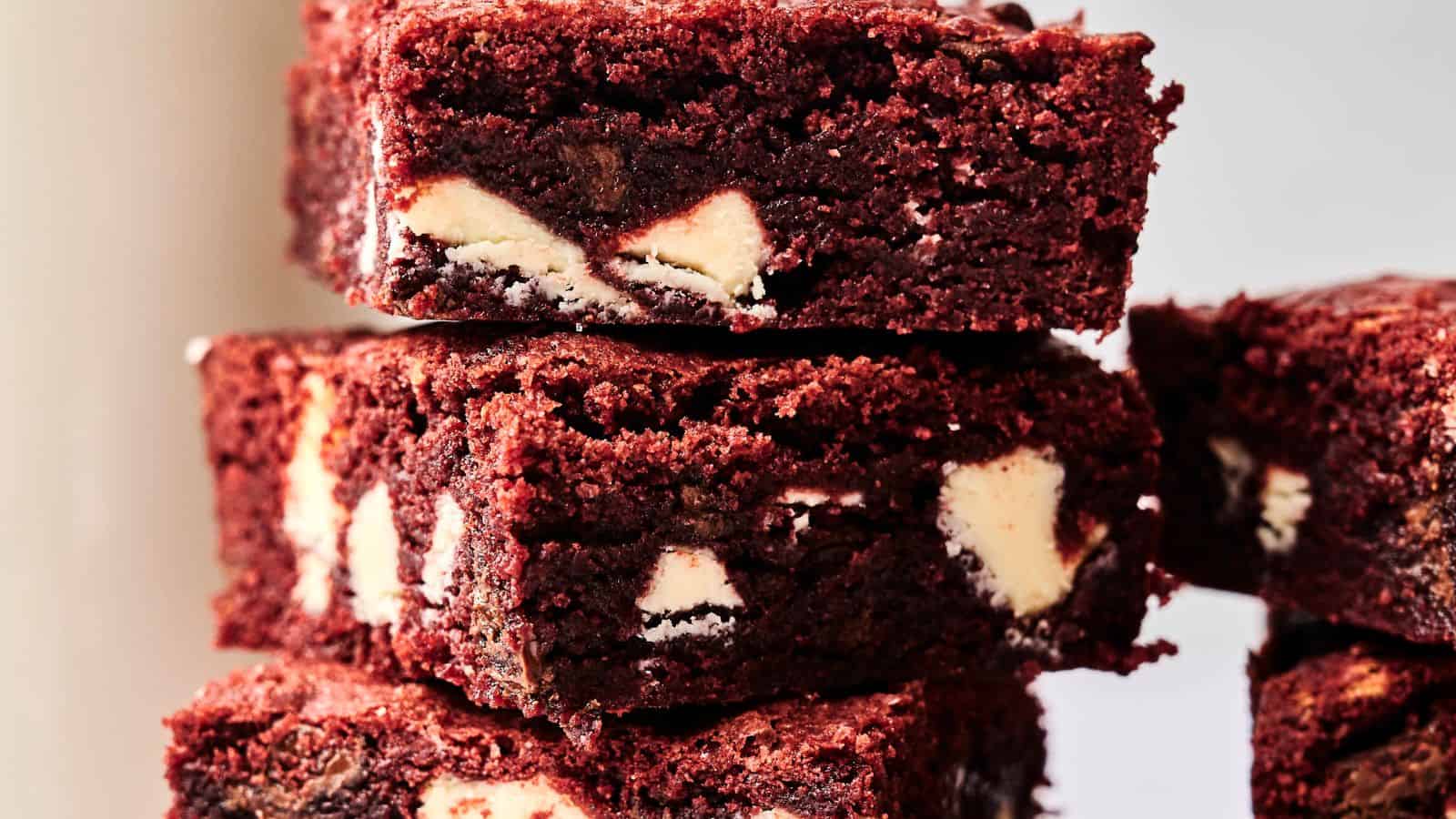 Stack of four chocolate brownies with visible white chocolate chunks.