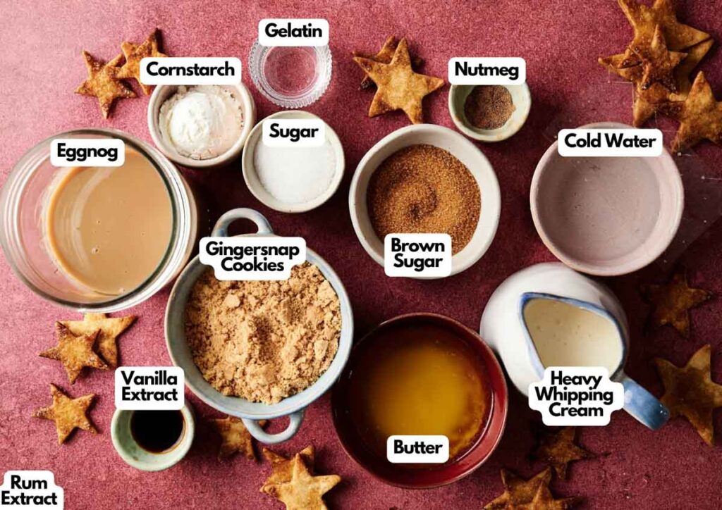 Various labeled baking ingredients for Eggnog Pie, including eggnog, gingersnap cookies, butter, sugar, brown sugar, gelatin, cornstarch, nutmeg, cold water, vanilla extract, rum extract, and heavy whipping cream.