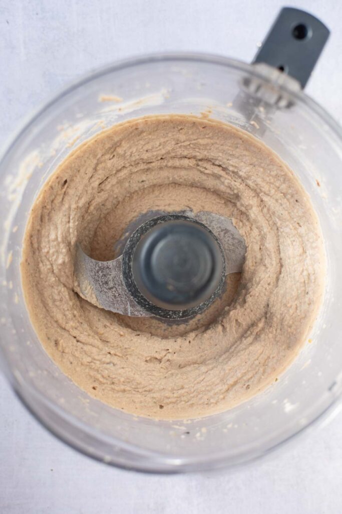 A food processor bowl filled with a smooth, light brown Smoked Mackerel Pate mixture, viewed from above.