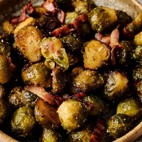 A bowl of Brussels Sprouts with Bacon features roasted Brussels sprouts perfectly mixed with crispy bacon pieces.