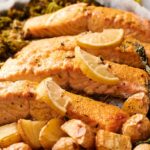 Sheet Pan Salmon fillets baked with lemon slices, roasted potatoes, and asparagus arranged on a baking sheet for an easy, flavorful meal.