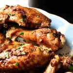 Plate of crispy Air Fryer Turkey Wings garnished with chopped parsley, served on a light-colored dish.