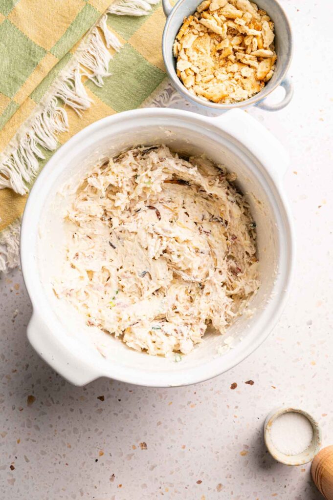 A white bowl filled with chicken mixture for Air Fryer Neiman Marcus Chicken Casserole.
